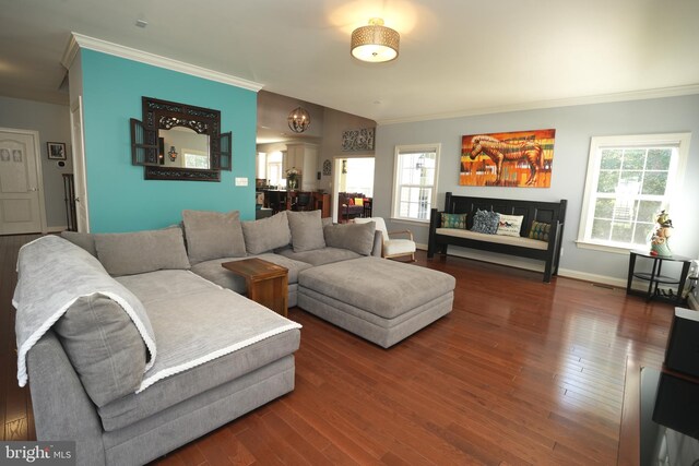 living room with vaulted ceiling, crown molding, baseboards, and wood finished floors