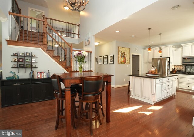 dining space featuring recessed lighting, dark wood-style flooring, baseboards, and stairs