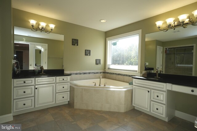 full bath featuring a bath, tile patterned floors, a notable chandelier, and vanity