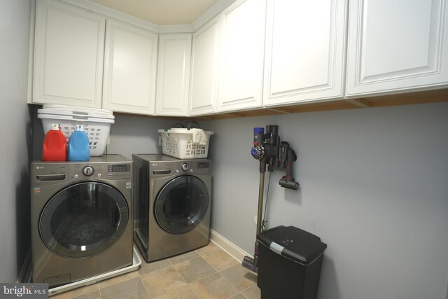 laundry area with washer and clothes dryer, cabinet space, and baseboards