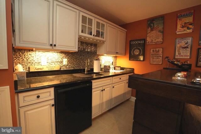 kitchen featuring black dishwasher, glass insert cabinets, white cabinets, and a sink