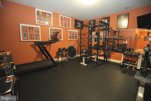 exercise room with visible vents and baseboards