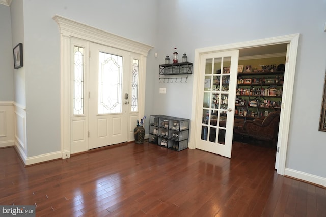 foyer featuring french doors, dark wood-style flooring, and wainscoting