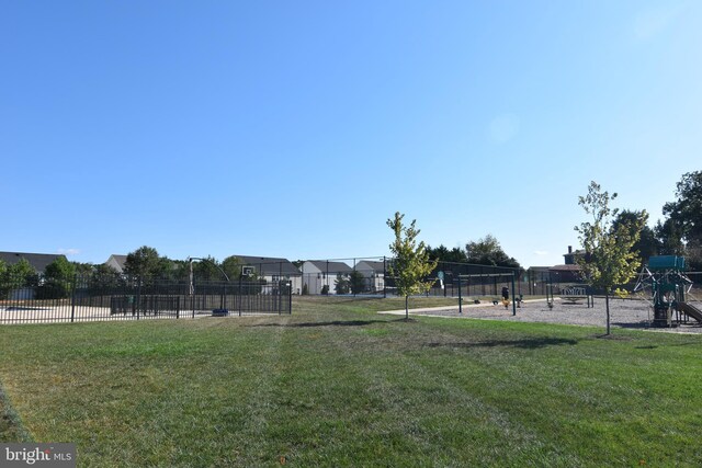 view of home's community with playground community, a yard, and fence