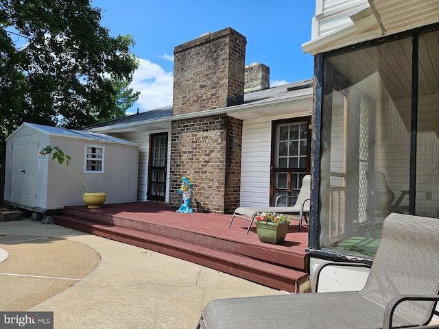 exterior space featuring a deck and a storage shed