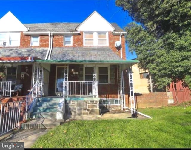 view of front of house with covered porch and a front yard