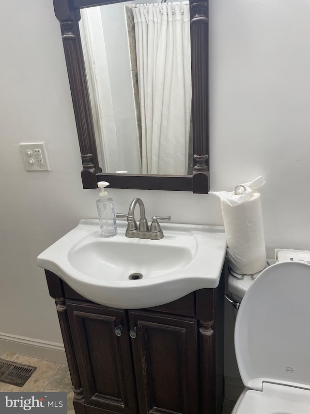 bathroom with vanity, toilet, and tile patterned flooring