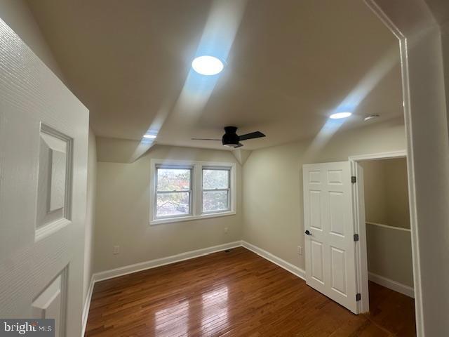 bonus room with dark wood-style floors, ceiling fan, and baseboards