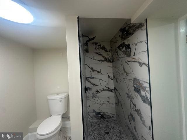 full bath featuring marble finish floor, a marble finish shower, and toilet