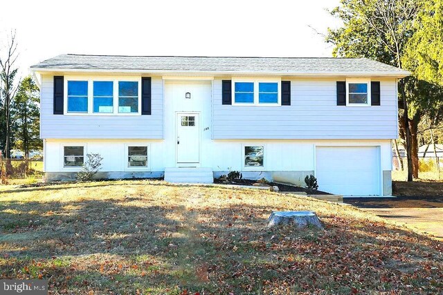 bi-level home featuring a front yard and a garage