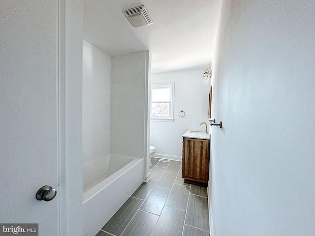 full bath with baseboards, visible vents, vanity, and toilet