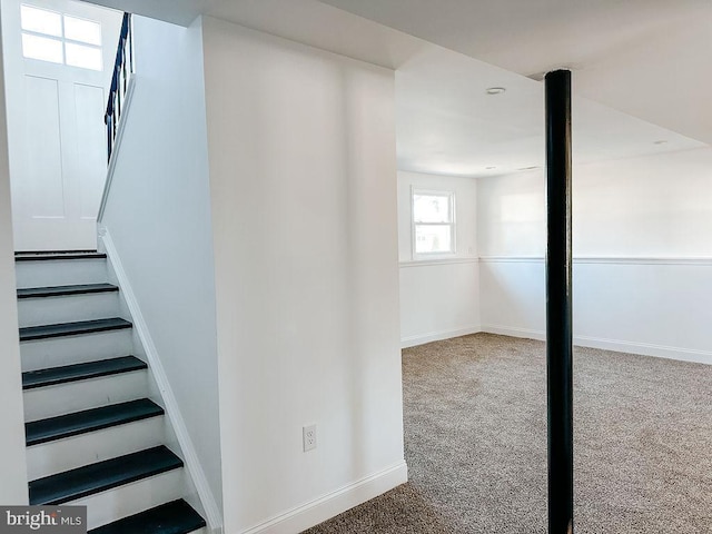 staircase featuring carpet and baseboards