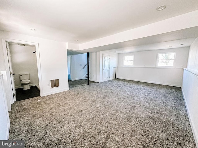 unfurnished bedroom with carpet, visible vents, ensuite bath, and baseboards