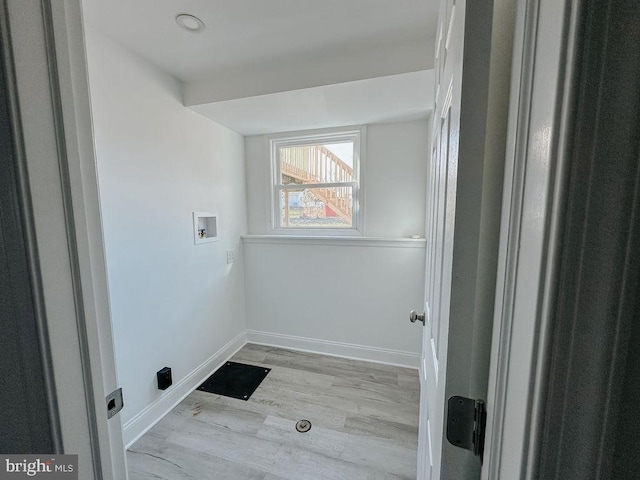 laundry area featuring light wood-type flooring, laundry area, baseboards, and washer hookup