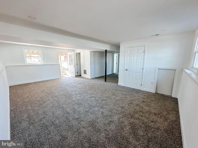 carpeted spare room featuring visible vents and baseboards