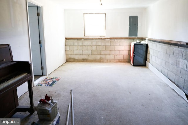 basement featuring electric panel and concrete block wall