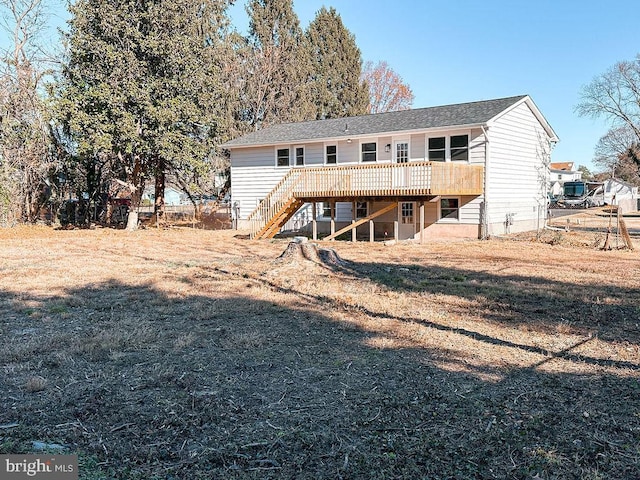 rear view of house with a yard, stairway, and a wooden deck