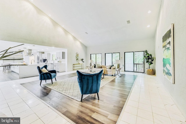 living area with light tile patterned floors, recessed lighting, and high vaulted ceiling