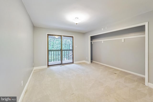 unfurnished bedroom with a closet, baseboards, carpet, and access to outside