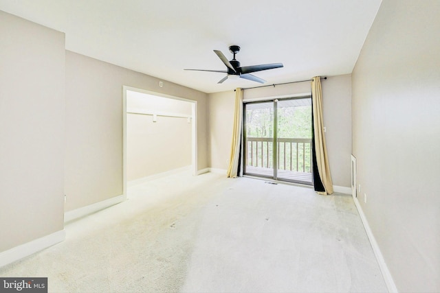 carpeted spare room featuring a ceiling fan and baseboards