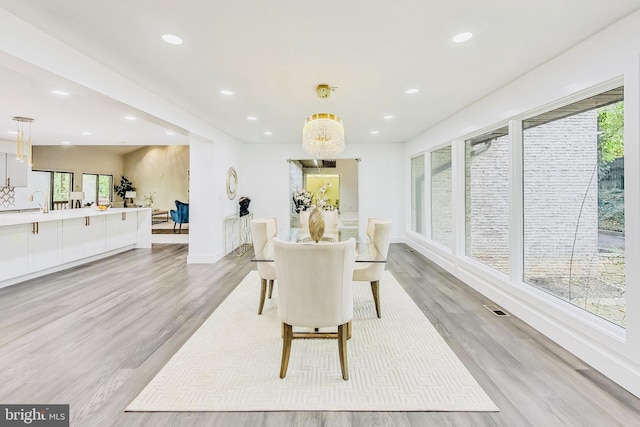 dining room featuring light wood-style flooring, recessed lighting, visible vents, and a wealth of natural light