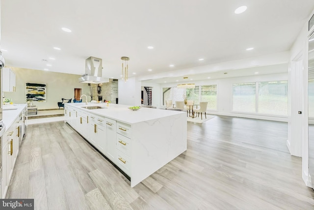 kitchen featuring recessed lighting, open floor plan, white cabinets, and a large island