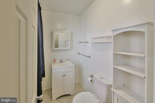 bathroom featuring toilet, tile patterned floors, baseboards, and vanity