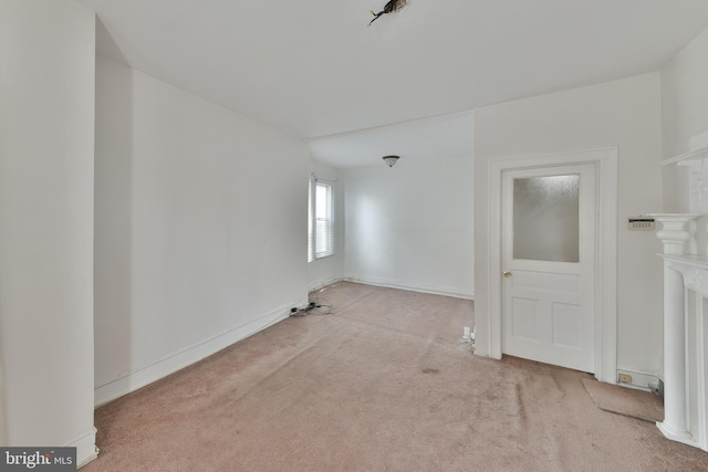 empty room featuring a fireplace and light colored carpet