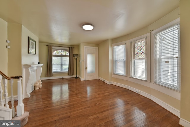 entrance foyer with stairway, wood finished floors, and baseboards