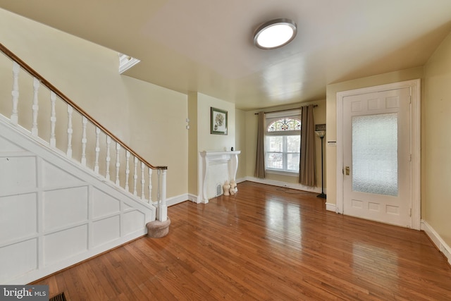 foyer entrance featuring stairway, wood finished floors, and baseboards