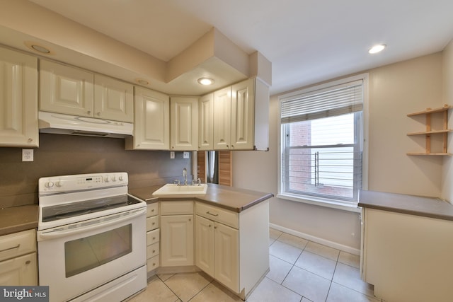 kitchen with light tile patterned floors, under cabinet range hood, a peninsula, a sink, and electric stove