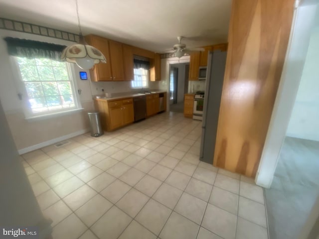 kitchen with brown cabinets, light tile patterned floors, light countertops, visible vents, and appliances with stainless steel finishes