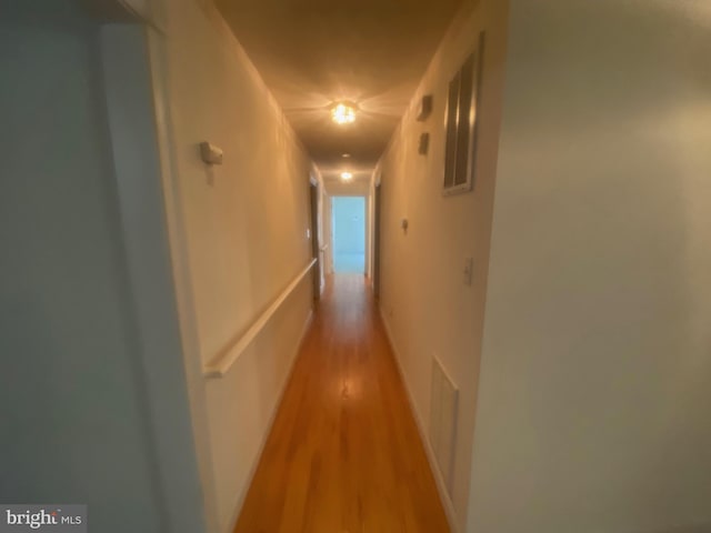 corridor featuring light wood-style flooring and visible vents