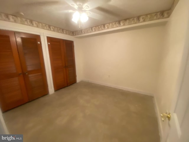 unfurnished bedroom featuring two closets, a ceiling fan, and baseboards