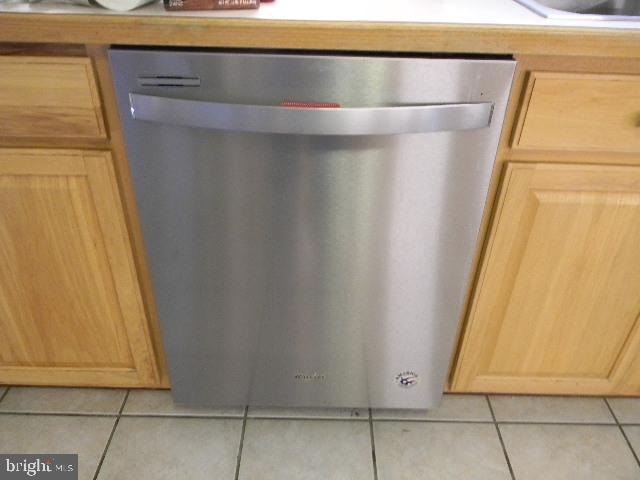 room details featuring dishwasher, light brown cabinetry, and light tile patterned floors