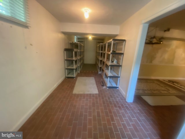 basement with brick floor and baseboards