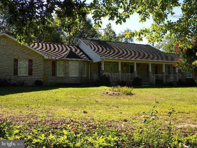 view of front of house featuring stone siding and a front lawn