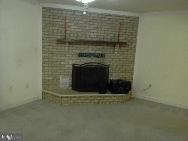 unfurnished living room with carpet, crown molding, and a brick fireplace