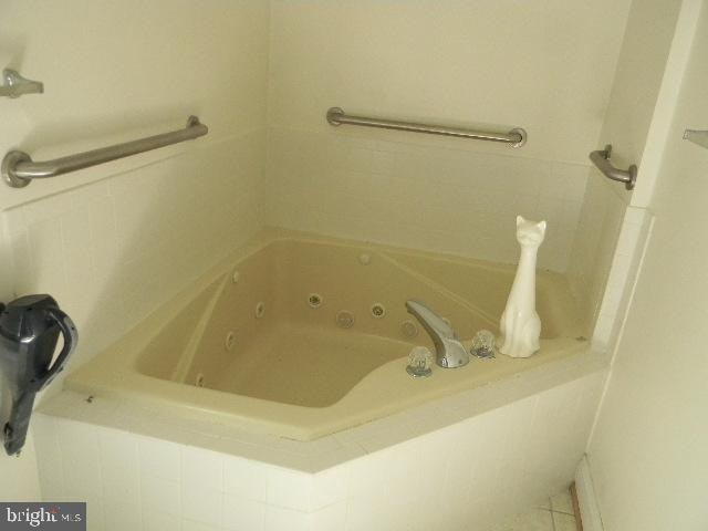 bathroom featuring tiled tub and tile patterned floors