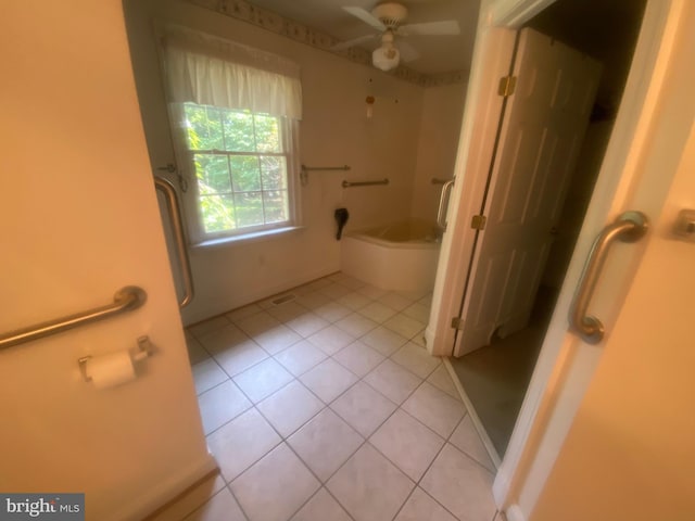 bathroom featuring ceiling fan, a garden tub, and tile patterned floors