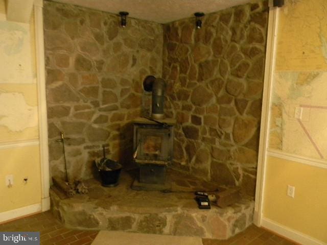 room details featuring a wood stove and baseboards