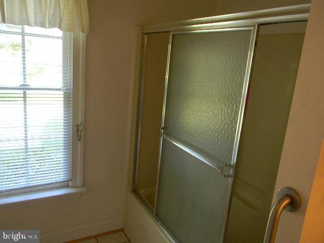 bathroom with a healthy amount of sunlight and enclosed tub / shower combo