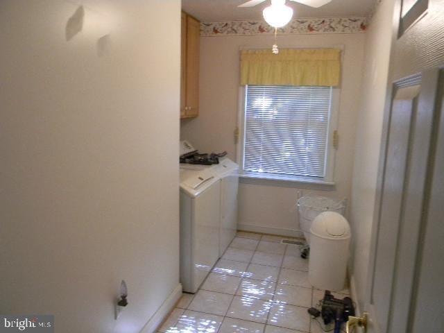 laundry room with light tile patterned floors, washer and clothes dryer, cabinet space, and baseboards