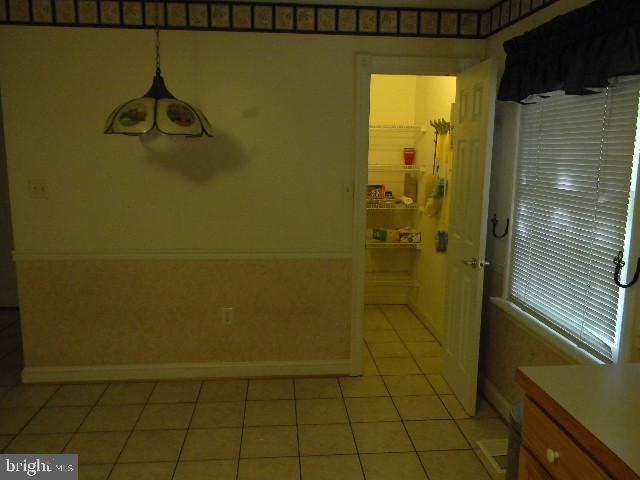 unfurnished dining area featuring light tile patterned floors and baseboards