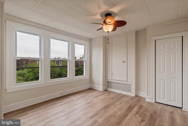 unfurnished bedroom with ceiling fan, crown molding, and light wood-type flooring