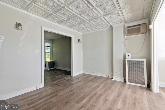 unfurnished room with radiator, crown molding, light hardwood / wood-style flooring, and a wall unit AC