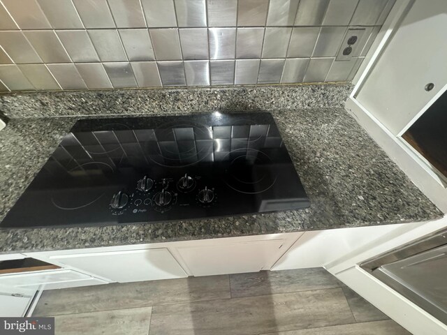 room details with stone counters, black electric cooktop, and tile patterned floors