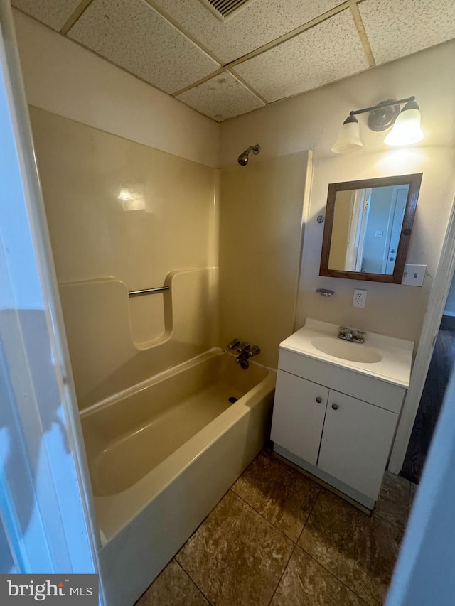 bathroom featuring vanity, a paneled ceiling, and washtub / shower combination