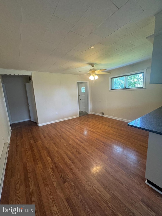 interior space featuring baseboard heating, ceiling fan, and dark hardwood / wood-style floors