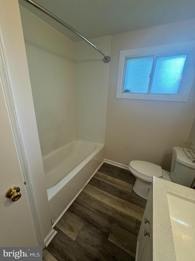 full bathroom featuring toilet, hardwood / wood-style flooring, tub / shower combination, and a healthy amount of sunlight